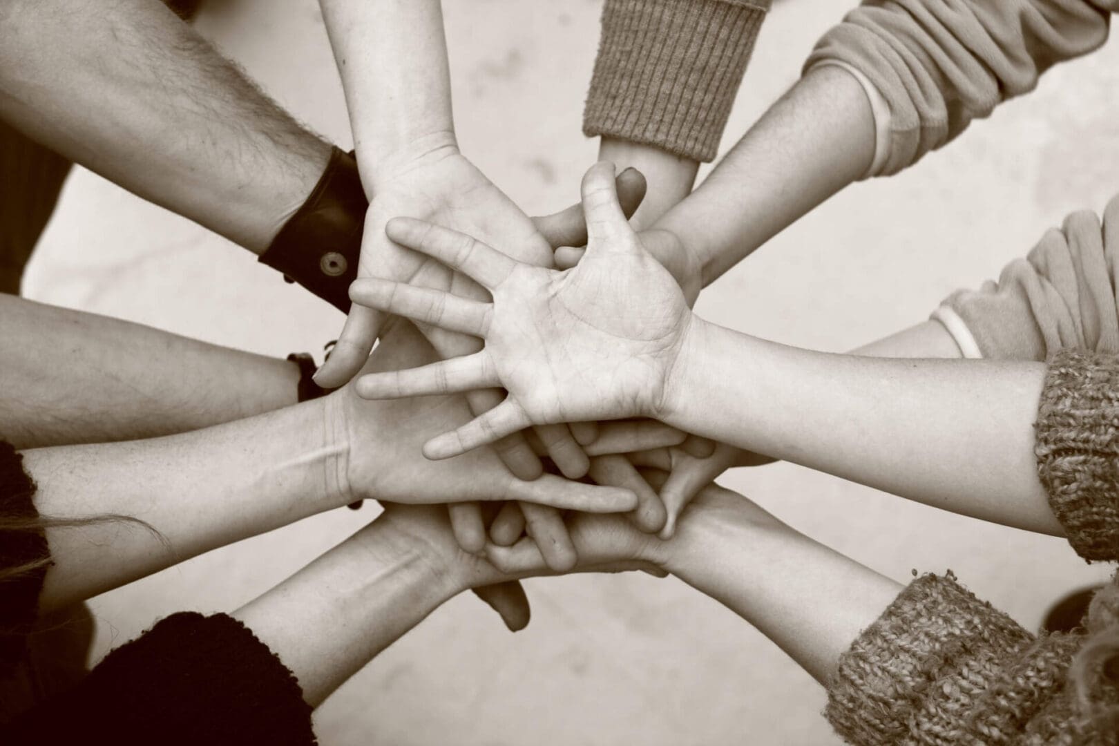 A group of people holding hands in the middle of a circle.