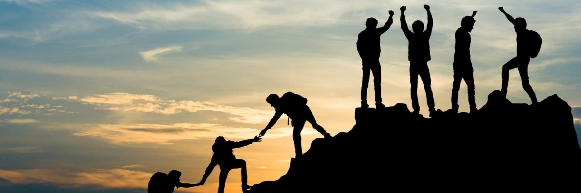 A group of people climbing up the side of a mountain.