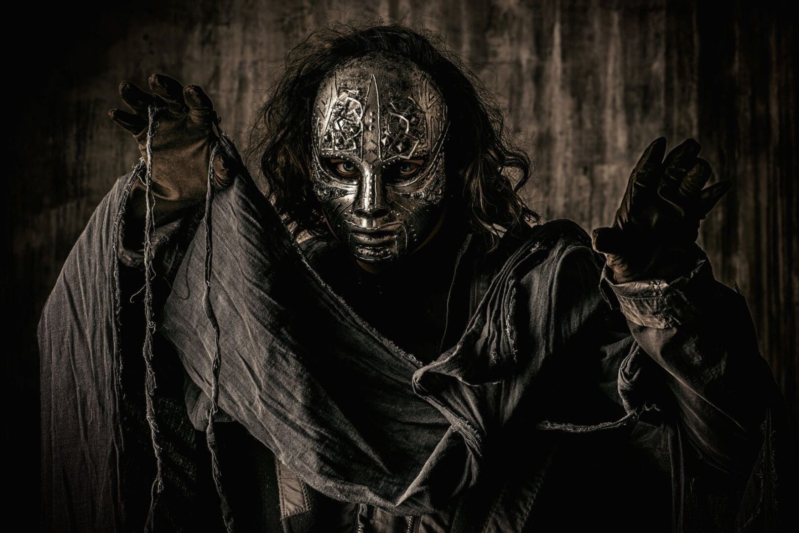 Masked figure in dark, dramatic lighting.